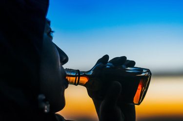 man-drinking-small-bottle-spirit